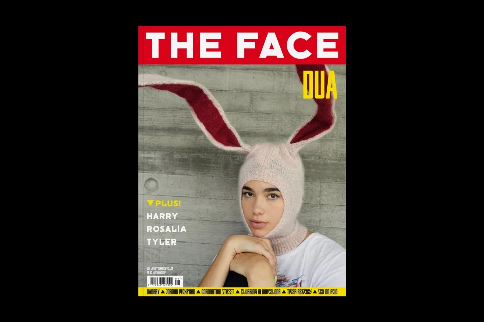 Magazine cover featuring a fair-skinned person wearing a pink knit balaclava with bunny ears, set against a concrete background.