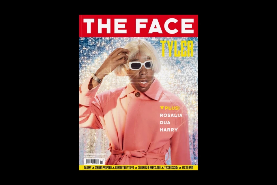 Magazine cover featuring Tyler, the Creator wearing sunglasses and a pink jacket, standing in front of a glittering background.