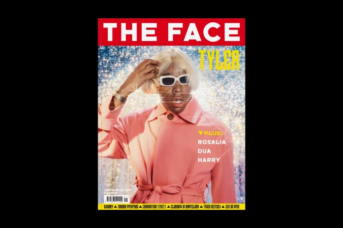 Magazine cover featuring Tyler, the Creator wearing sunglasses and a pink jacket, standing in front of a glittering background.