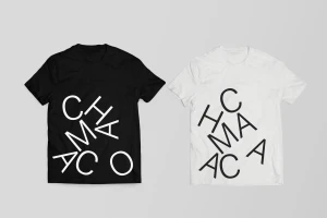 Two t-shirts displayed side by side on a plain grey background, one black with white typography and one white with black typography.