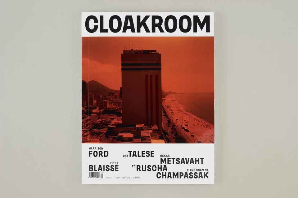 Cloakroom magazine cover with skyscraper and beach at sunset, featuring Harrison Ford, Gay Talese, and Oskar Metsavaht.