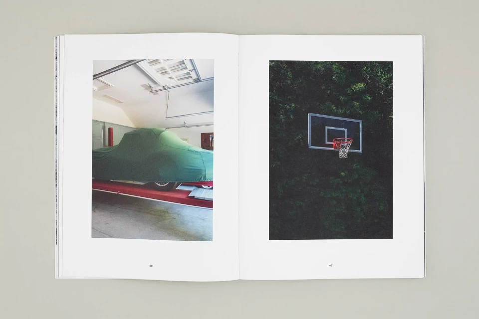 Photograph of a book spread with images of a car covered by a green tarp in a garage and a basketball hoop surrounded by trees.