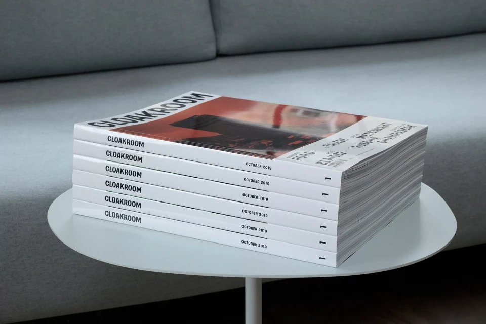 Stack of Cloakroom magazines on a white table. Each magazine cover features the publication's name and 'October 2019' printed on it.