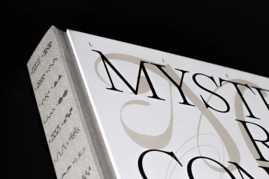 Close-up angle of a hardcover book spine and cover featuring elegant typography and symbolic line illustrations.