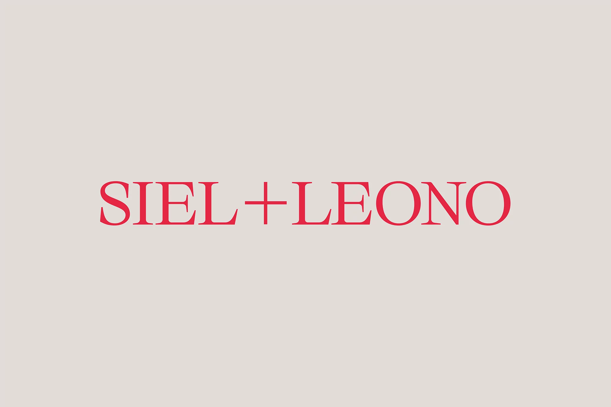 Minimalist studio shot of the text, SIEL+LEONO, in a vibrant red hue, set against a neutral, light-beige backdrop. Simple design.