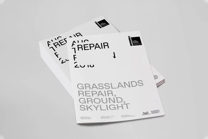 Stacks of architectural reports featuring the text 'Grasslands Repair, Ground, Skylight' in grey against a light grey backdrop.