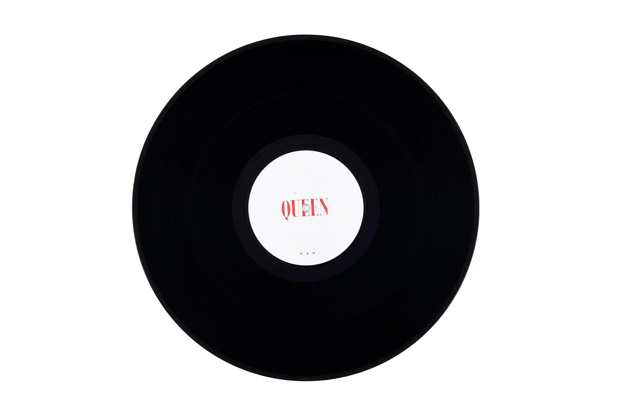 A black vinyl record features a white label with the word QUEEN in red text; viewed from an overhead angle against a white background.