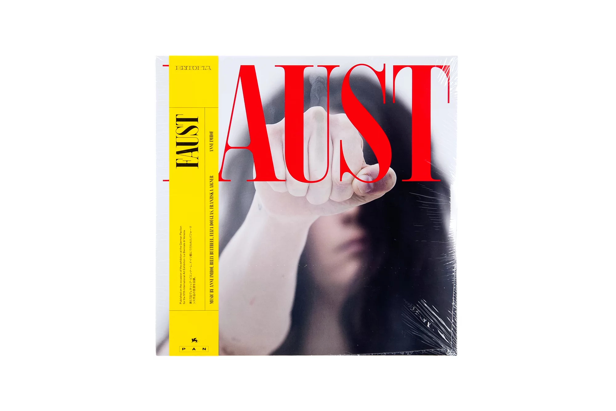 Album cover featuring a woman's hand in front of her blurred face and the red text 'AUST' on a white background.