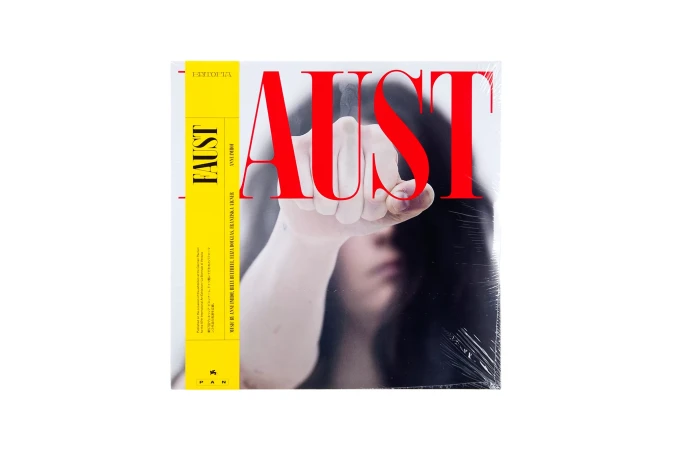 Album cover featuring a woman's hand in front of her blurred face and the red text 'AUST' on a white background.
