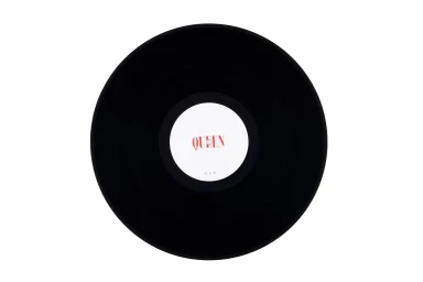Black vinyl record centered on a pure white background with a white label featuring red text reading Queen.