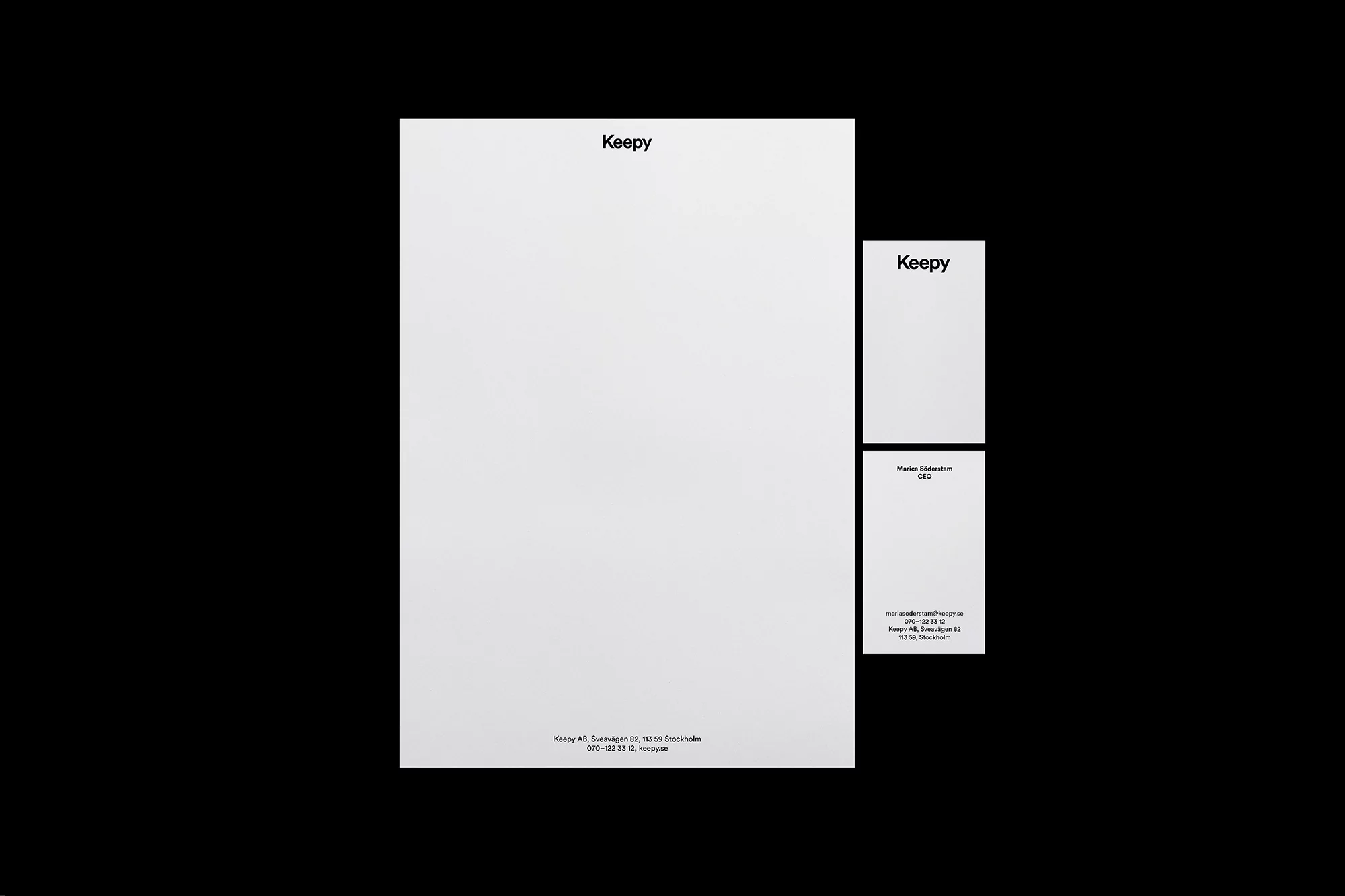 Letterhead stationery mock-up features letter paper and a business card in minimalist style, presented on a stark black background.