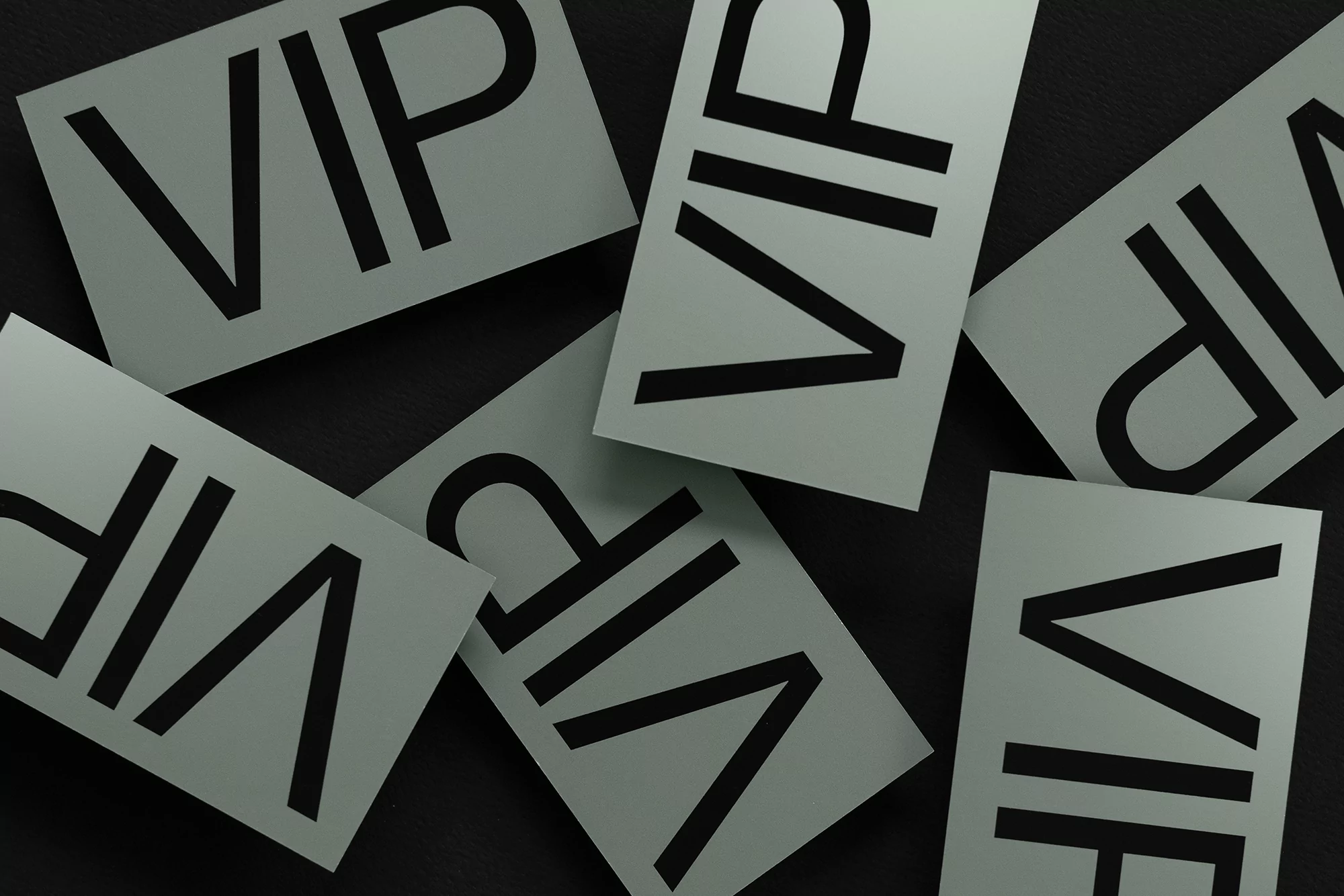 Overhead view of multiple VIP cards scattered across a black surface, creating a textured and patterned arrangement.