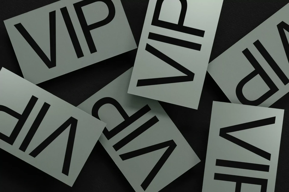Overhead view of multiple VIP cards scattered across a black surface, creating a textured and patterned arrangement.