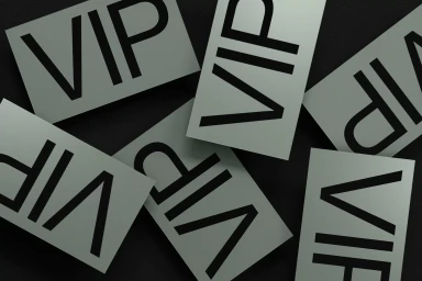 Multiple rectangular cards printed with bold black VIP typography scattered across a dark textured surface.