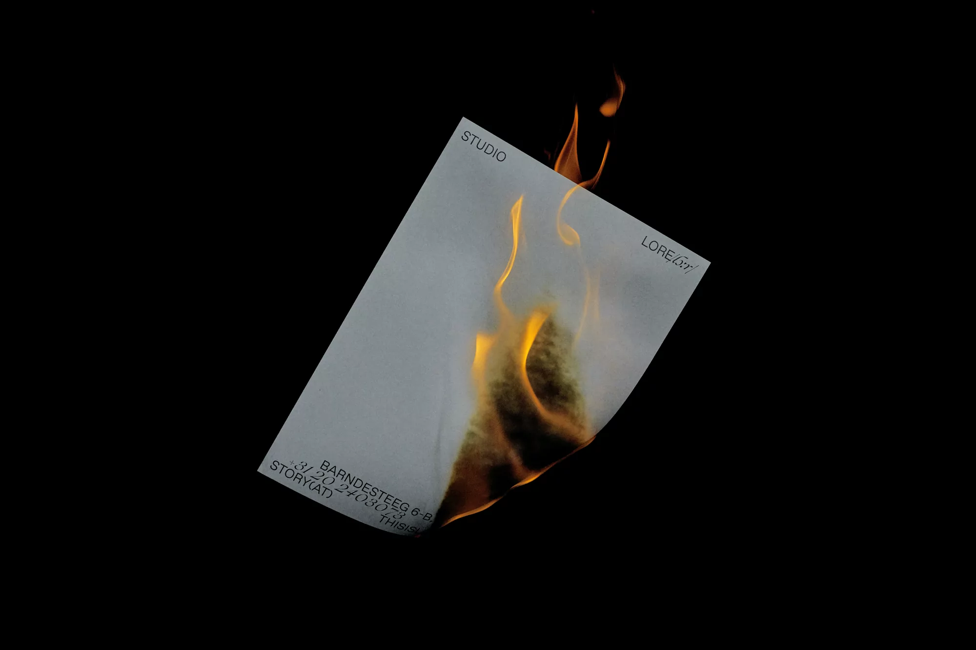 Burning white paper against a black backdrop, featuring graphic text and smoky flames. Dynamic composition and stark contrast.