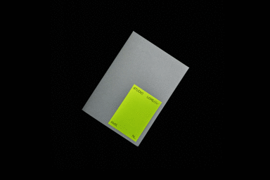 Grey paper document with a bright lime green label sticker displaying Studio Lore branding against black