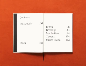 Open book displaying a contents page with typography on an orange background surface.