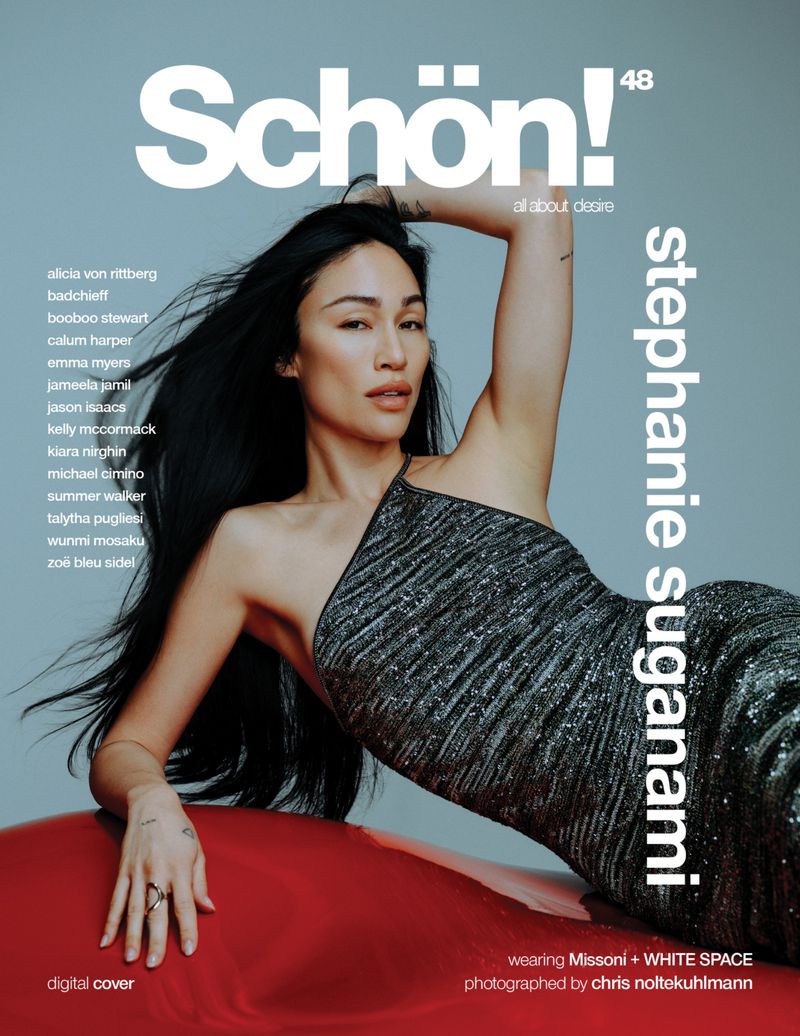 Schön! digital cover featuring Stephanie Suganami in a shimmering silver dress, posing on a red surface against a light blue background.