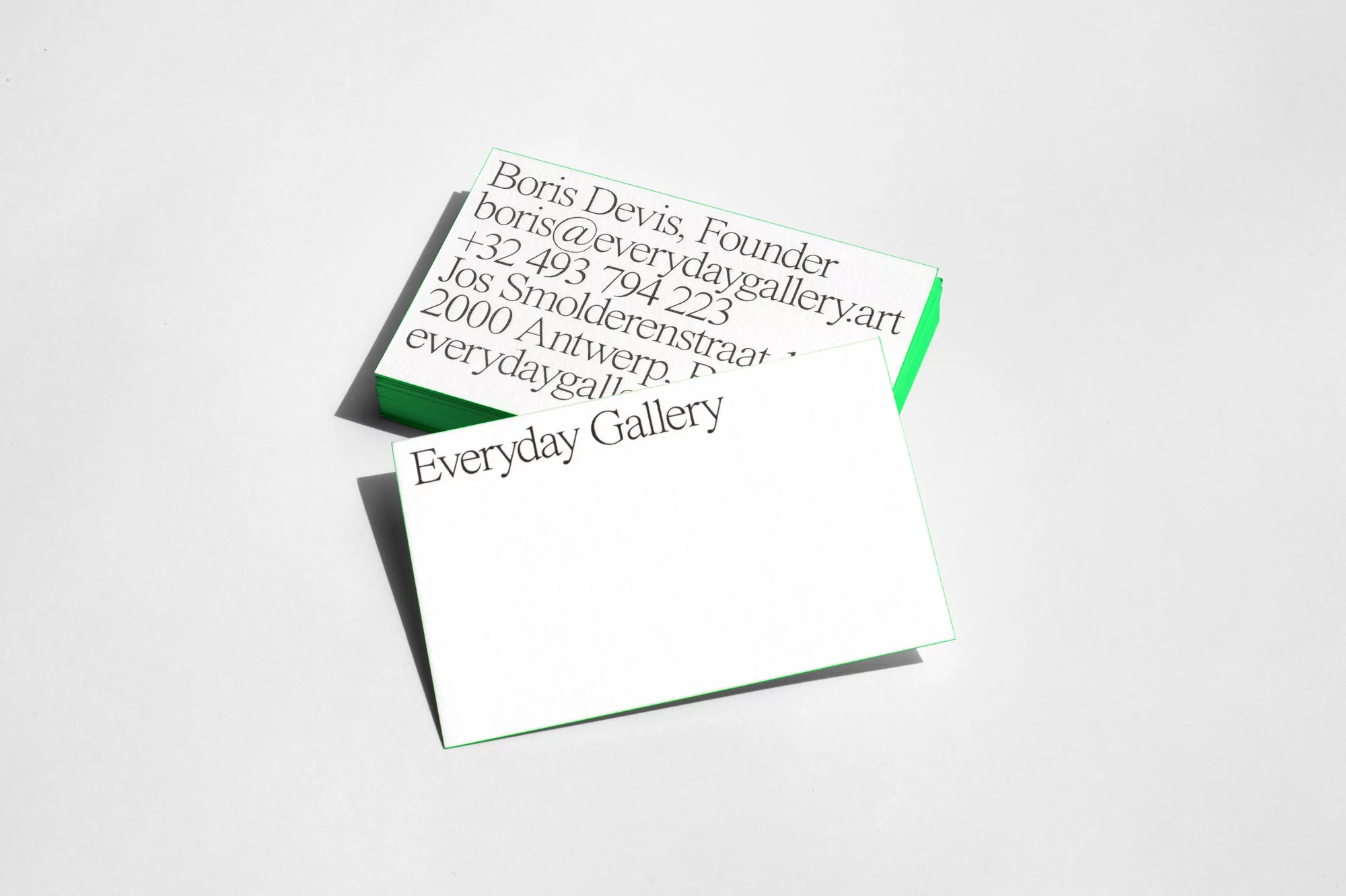 Two stacks of white and green business cards with the text 'Everyday Gallery' against a clean, light-grey background in a studio setting.