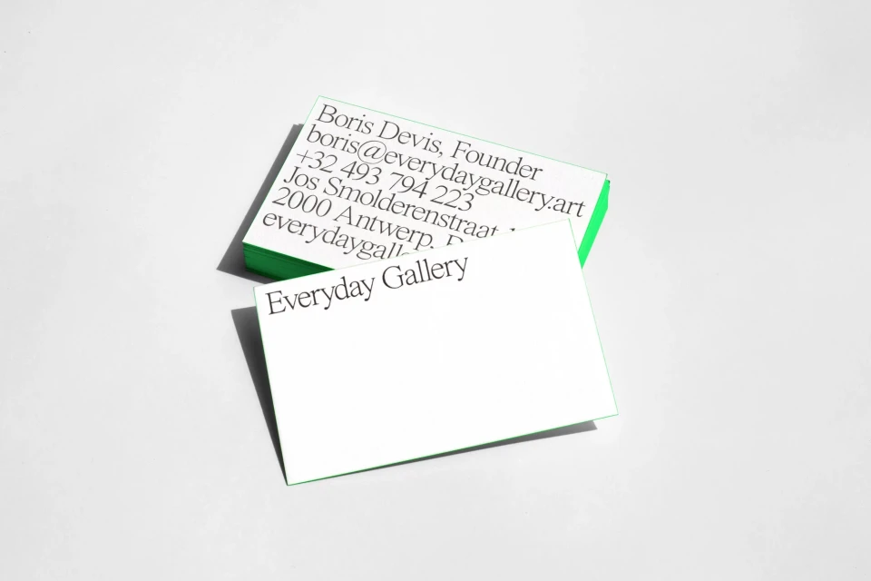 Two stacks of white and green business cards with the text 'Everyday Gallery' against a clean, light-grey background in a studio setting.