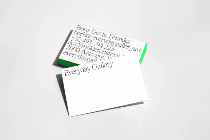 Two stacks of white and green business cards with the text 'Everyday Gallery' against a clean, light-grey background in a studio setting.