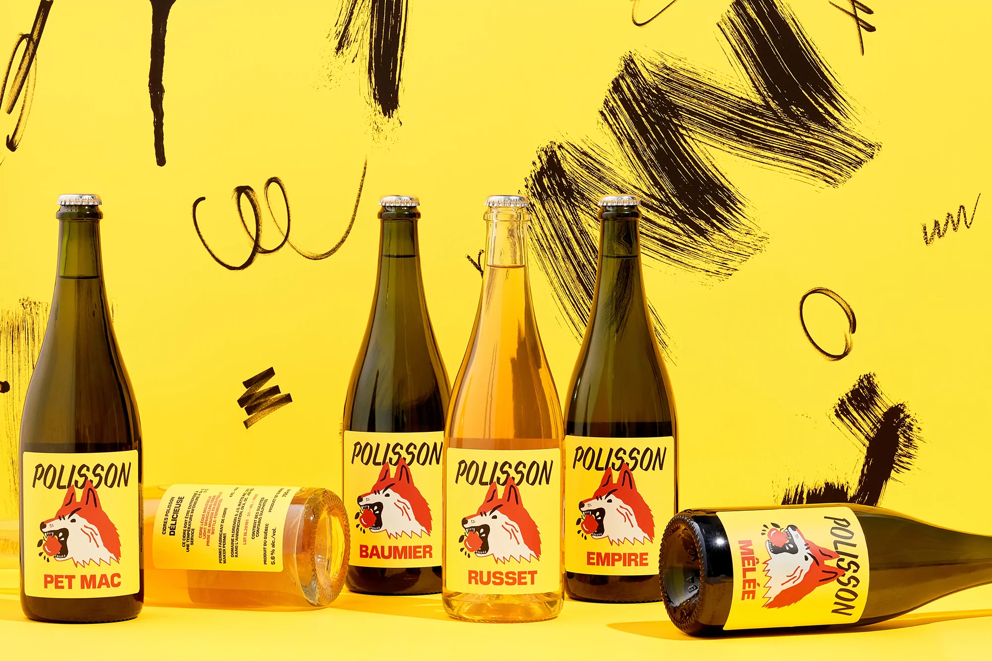 Several green glass bottles with brand labels are arranged on a yellow background with brushstroke decorations. Bottles contain liquid.