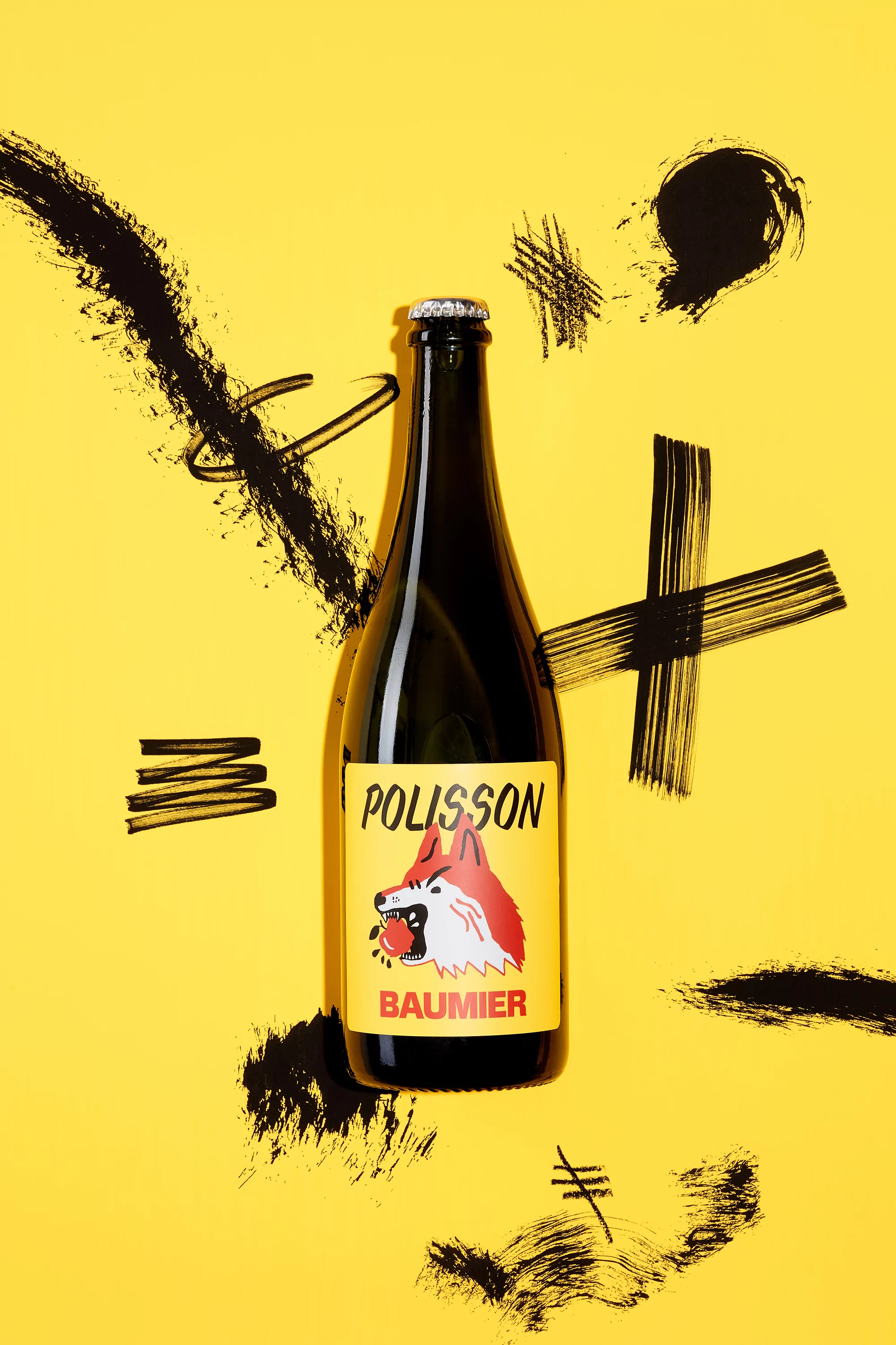 Studio shot of a dark glass bottle with a yellow label featuring a fox and 'Polisson Baumier' text, on a yellow background with black brush strokes.