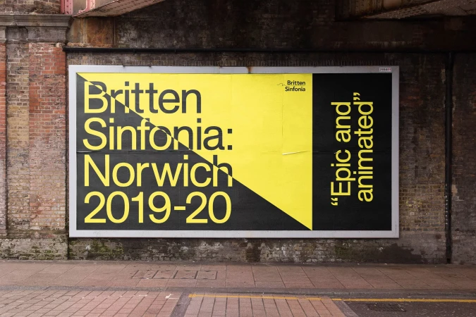 Billboard promoting Britten Sinfonia: Norwich 2019-20 under a bridge, featuring bold typography and graphic design in black and yellow.