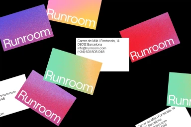 Scattered colorful gradient business cards with white Runroom typography against a black background.