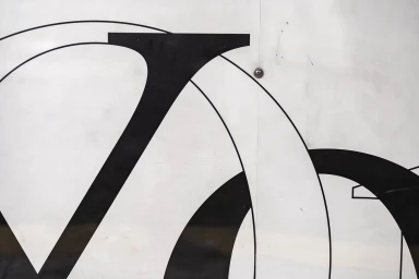 Close-up graphic design with bold black typography and curved lines on a white background for Yoko Ono brand identity.