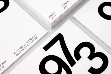Multiple white publications with bold black typography and clean minimalist layout arranged on a light grey surface.