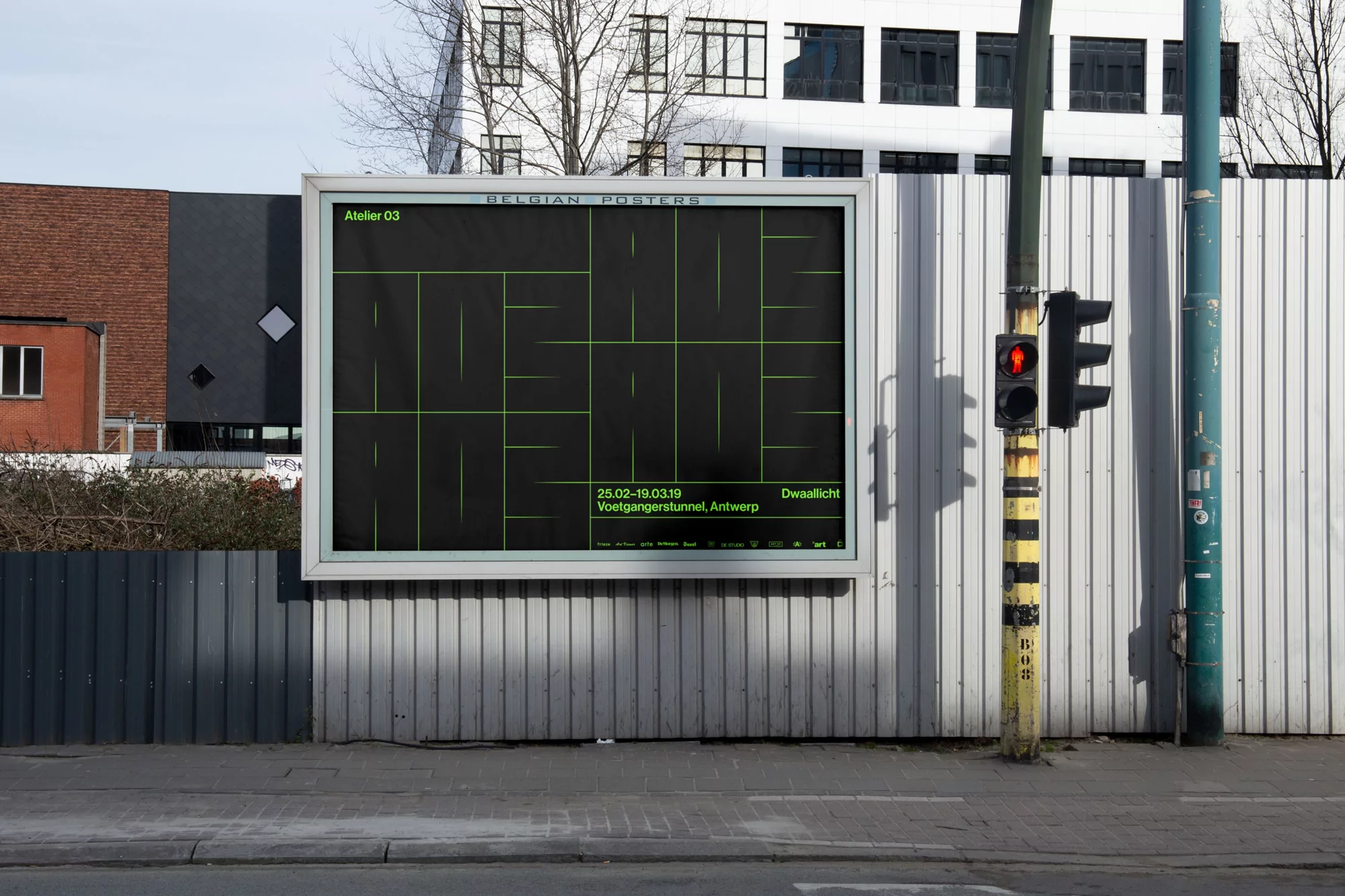 Outdoor advertising billboard featuring minimalist green-line art on a black background, placed on a gray fence along an urban street with a traffic light.