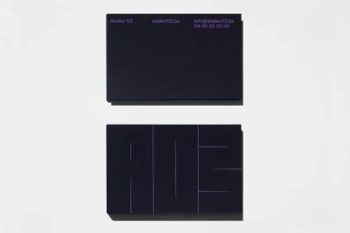 Two dark textured business cards with purple typography displayed against a clean white background
