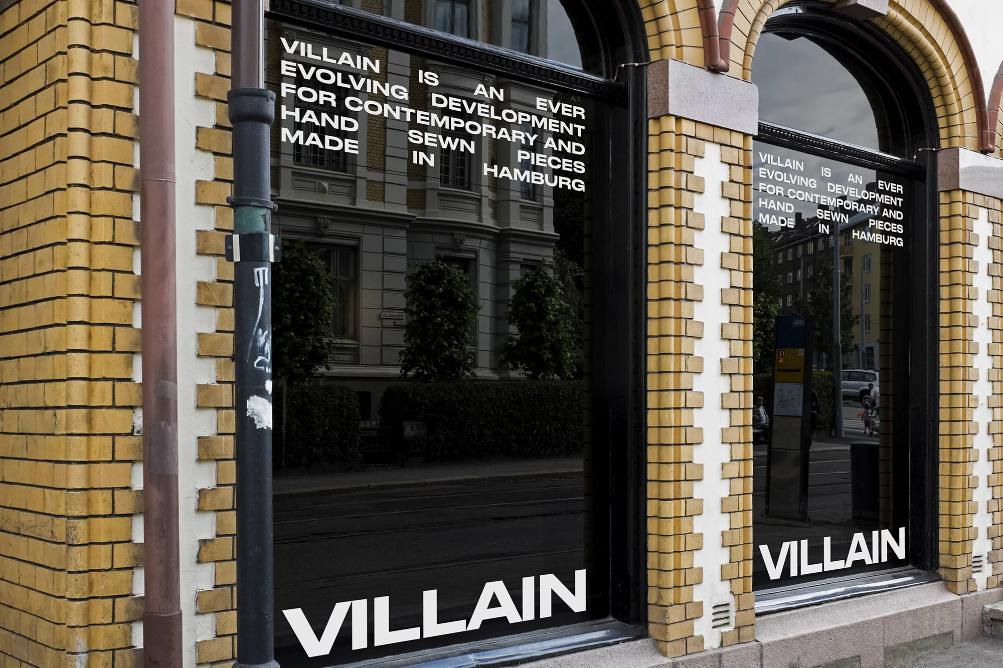 Exterior view of a building with glass windows displaying 'Villain' branding and architectural details, conveying an urban and commercial scene.
