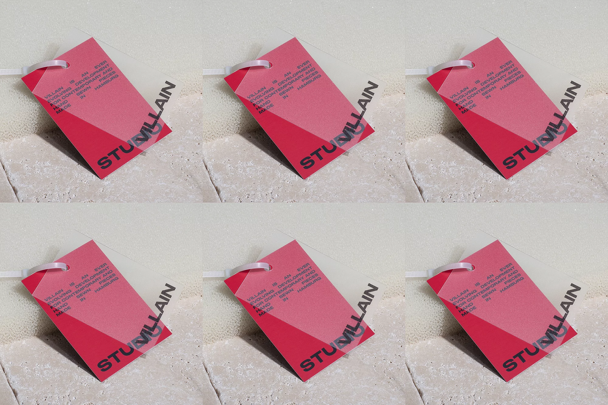 Multiple red tags with white lettering and a geometric color block, attached with plastic ties and set against a textured backdrop.