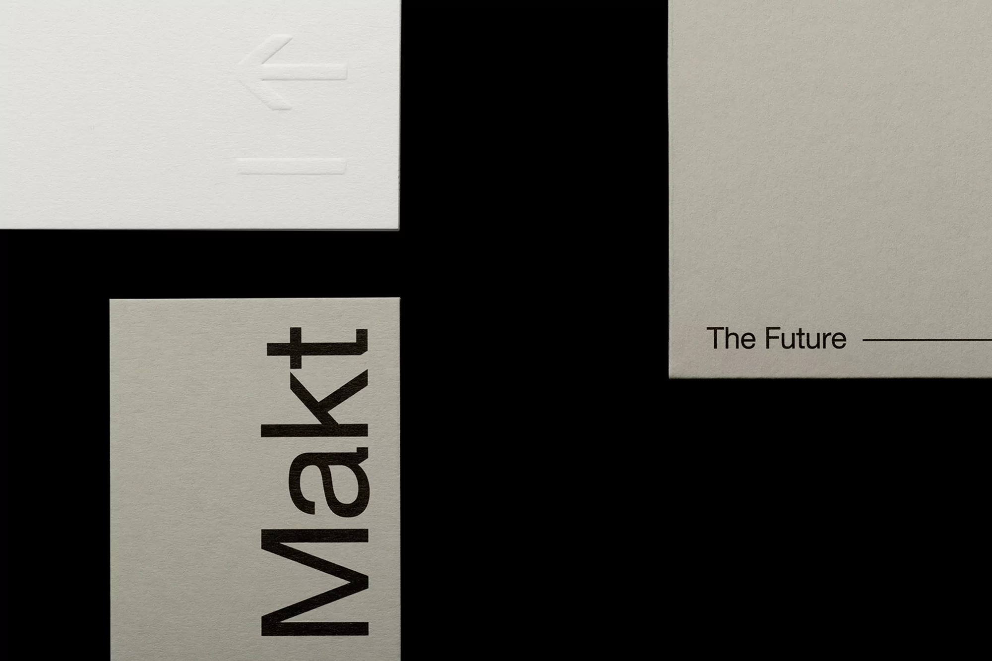 Abstract close-up of three cards featuring the text 'Makt,' 'The Future,' and an arrow, set against a stark black backdrop.