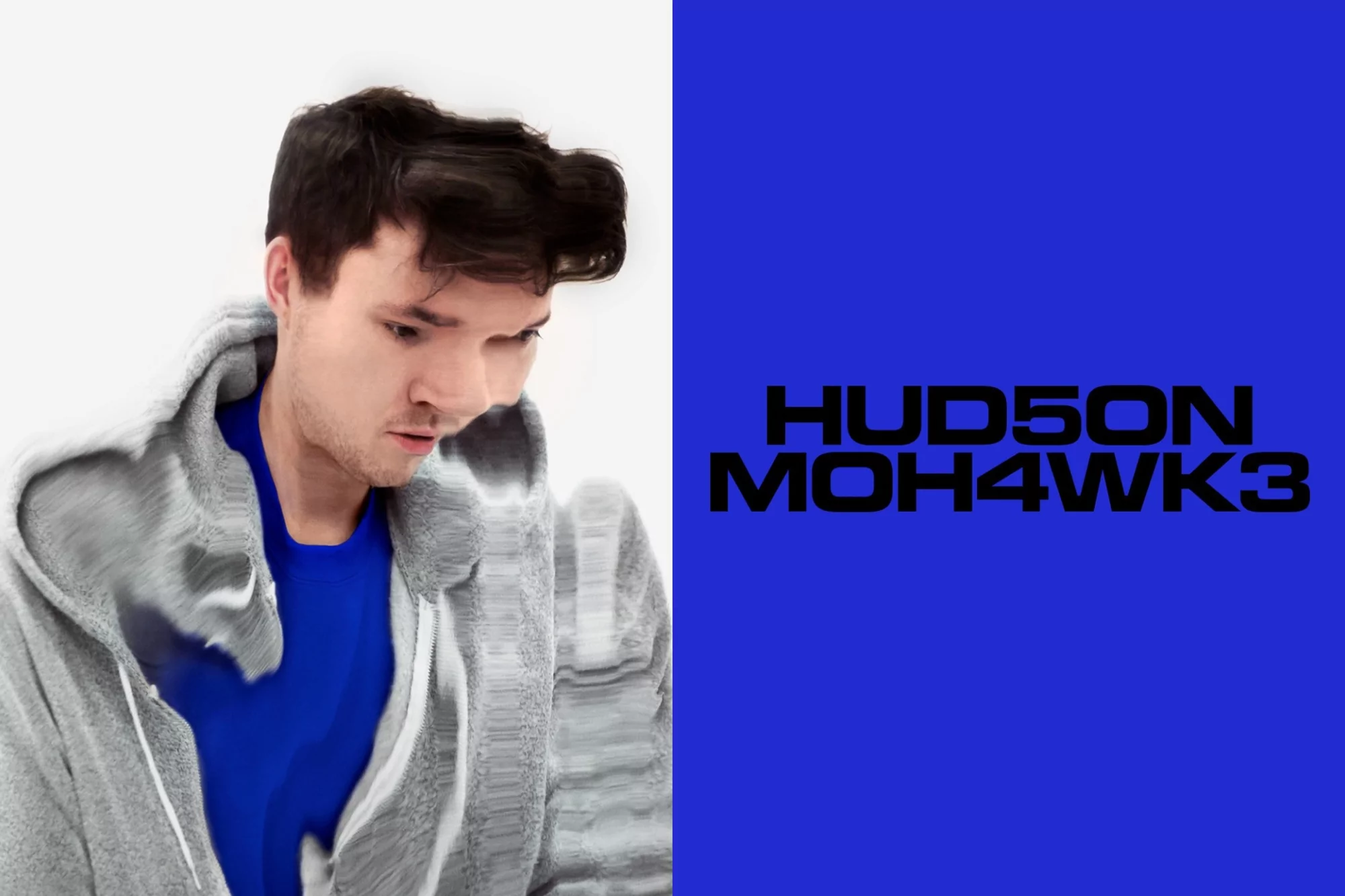 Portrait of a man in a grey hooded sweatshirt against a split background of white and blue with the text 'HUDSON MOHAWKE3'.