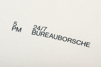 Close-up macro shot of minimalist black typography on white textured paper showing 5PM and BUREAUBORSCHE branding.