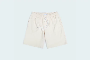 Cream-coloured shorts with a white drawstring waistband displayed flat against a light background.