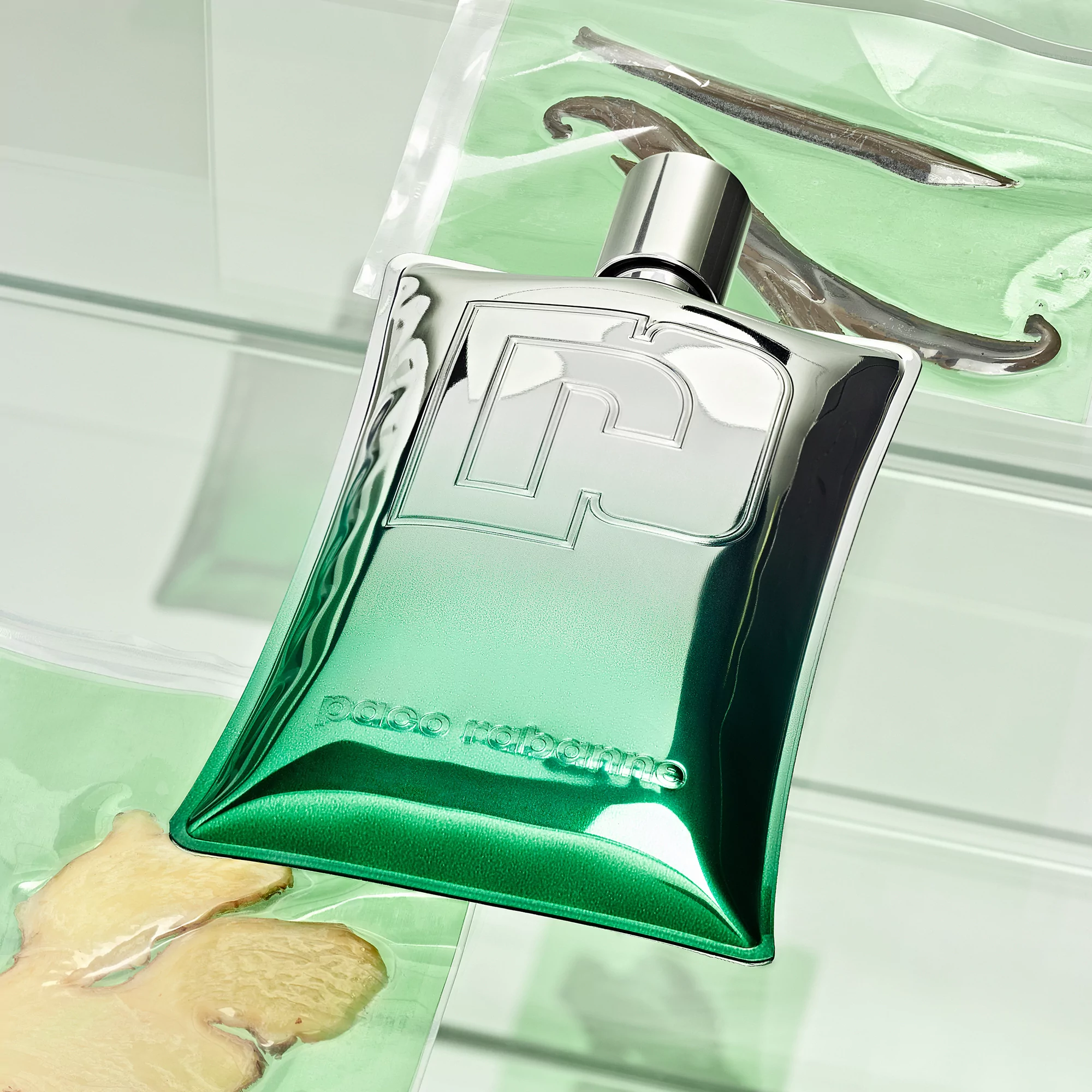 Close-up of a green and silver perfume bottle with vanilla bean and ginger in the background. Product shot, beauty and fragrance.