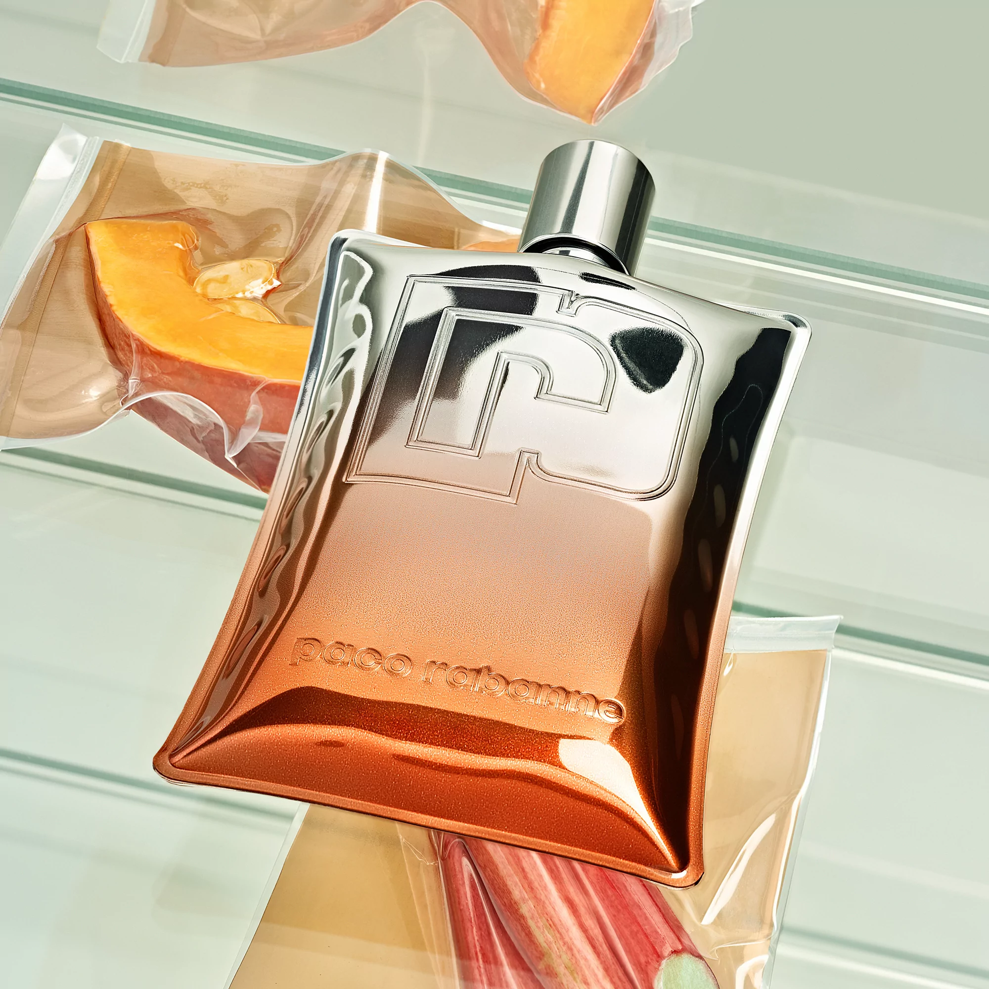 Paco Rabanne fragrance bottle in a refrigerator with vacuum-sealed food, creating a unique beauty and food juxtaposition.