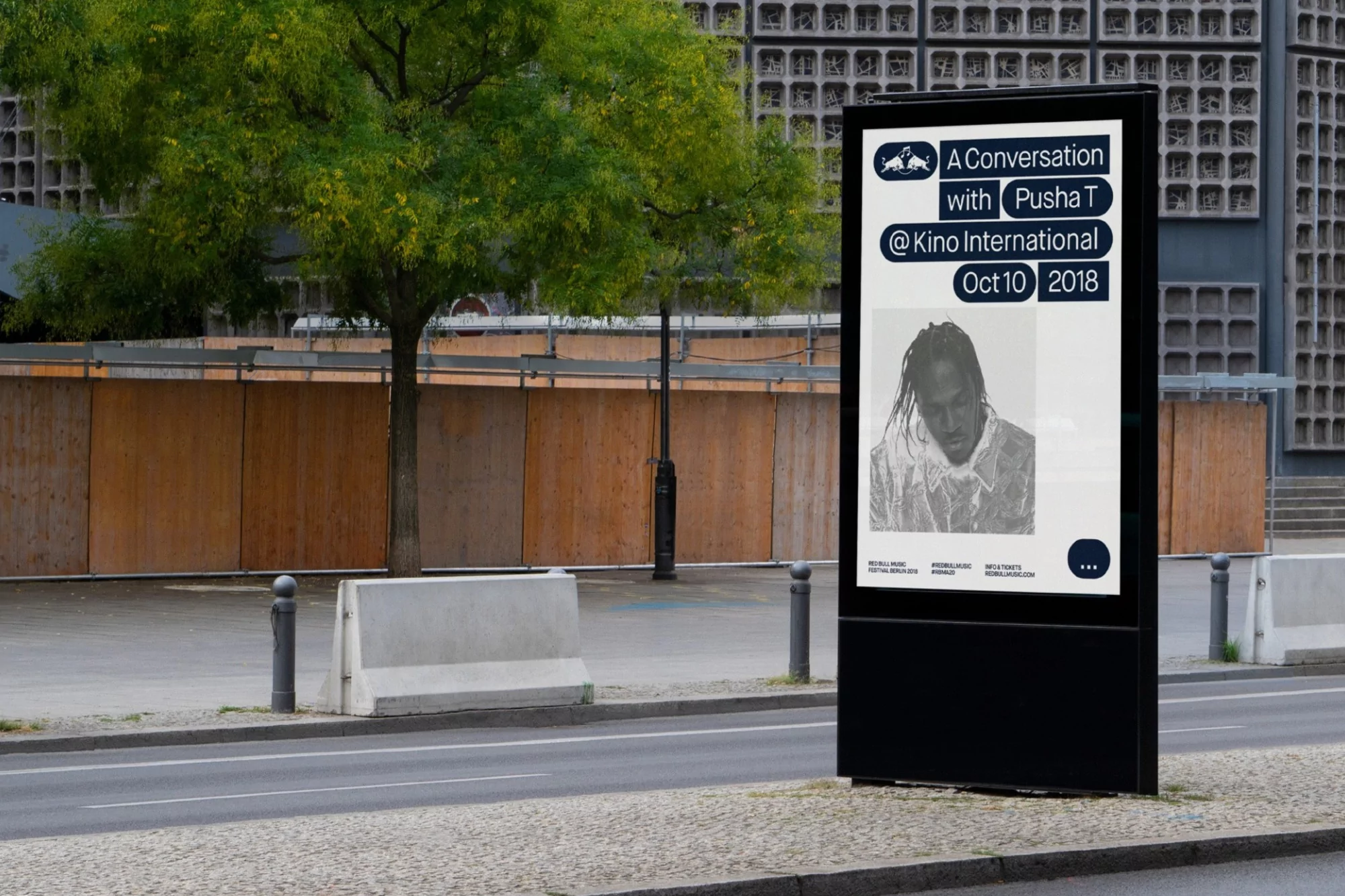 Outdoor advertising display featuring an advertisement for A Conversation with Pusha T at Kino International on Oct 10, 2018, in neutral tones.