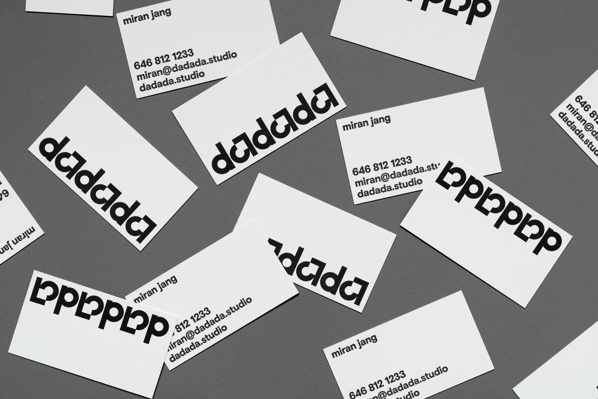 Scattered arrangement of white business cards featuring the name 'miran jang,' contact number '646 812 1233,' and email 'miran@dadada.studio.'