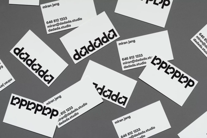 Scattered arrangement of white business cards featuring the name 'miran jang,' contact number '646 812 1233,' and email 'miran@dadada.studio.'