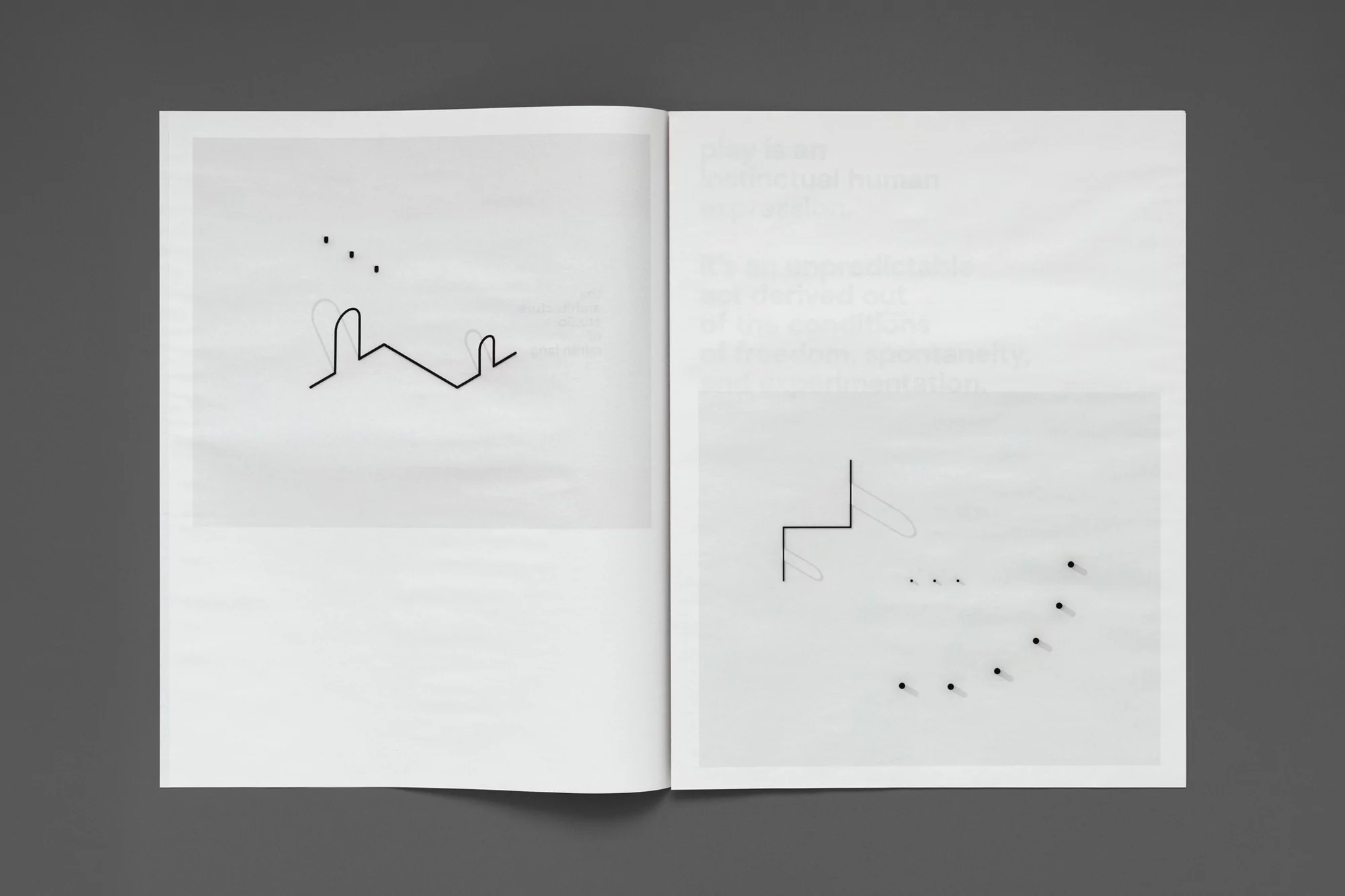 Open book displays minimalist line drawings and dot patterns on white pages, set against a solid dark gray background.