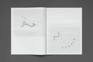 Open book spread showing minimalist black line drawings and dot patterns on white pages against a dark grey background.