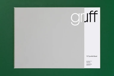 Gruff brand identity spiral-bound portfolio book resting on a dark green surface