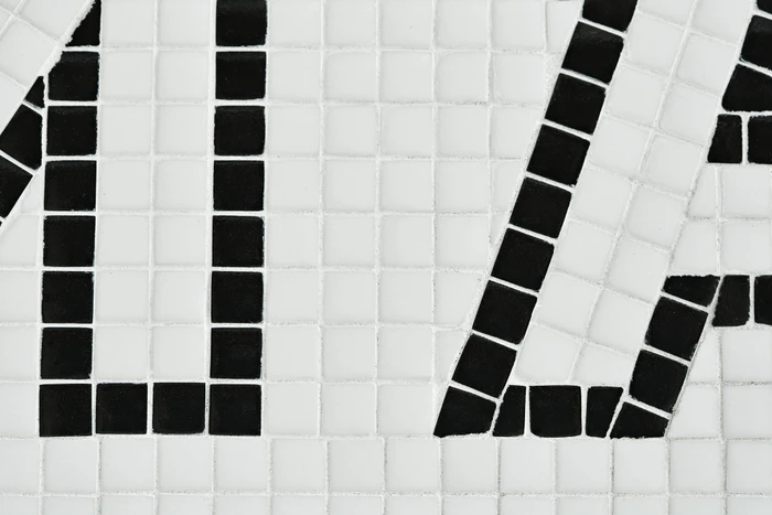 Close-up of black and white mosaic tile typography forming graphic letters on a flat surface