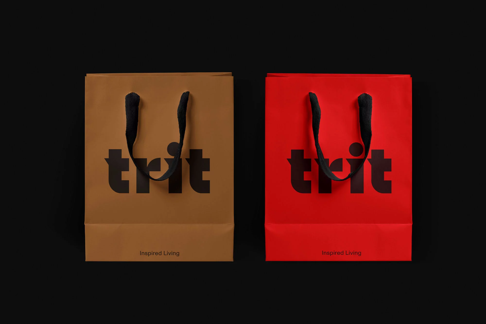 Two paper shopping bags, one tan and one red, with the brand logo 'trit' and the tagline 'Inspired Living' in a studio setting.