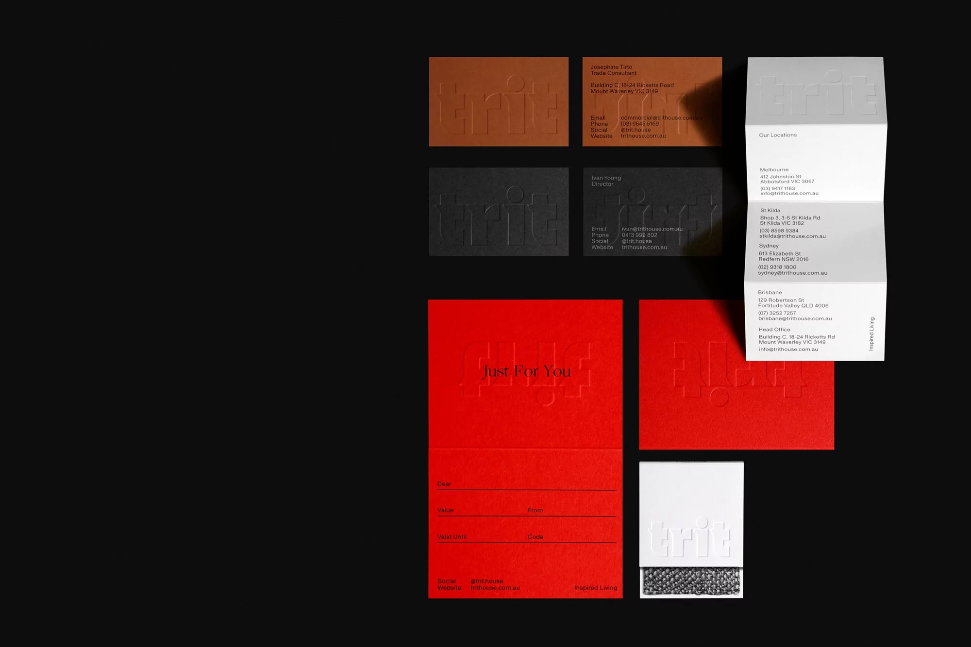 Arrangement of business cards and folded brochure in red, white, brown and black colors on a black background.
